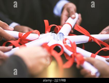 Quand il s'agit de l'éducation, aller tout dedans. Prise de vue d'un groupe d'étudiants détenant leurs diplômes ensemble le jour de la remise des diplômes. Banque D'Images