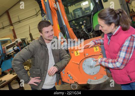 Jolie femme vendant tout nouveau tracteur pour agriculteur débutant Banque D'Images