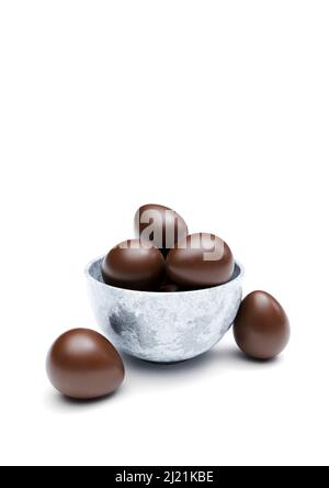 Chocolat au lait oeufs de pâques dans un bol en pierre sur fond blanc. Gros plan, centré Banque D'Images