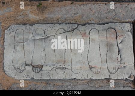 Plaque votive avec pieds gravés dédiée à Nemesis en Italica, un site archéologique à la périphérie de Séville. L'inscription dit: Aurelius · Banque D'Images