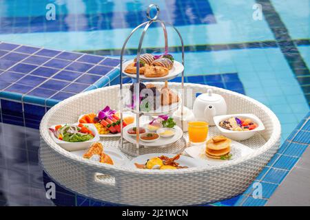 Petit déjeuner flottant dans un hôtel de luxe. Petit déjeuner dans la piscine de la villa Banque D'Images