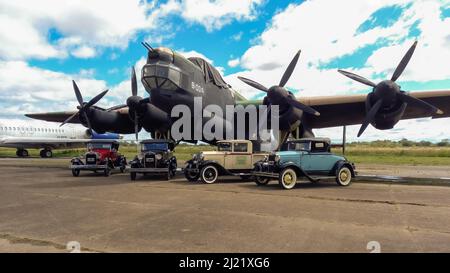 Plusieurs anciens Ford modèle A dans différents styles de carrosserie vers 1930 garés devant un bombardier à quatre moteurs Avro Lincoln MKII de la Seconde Guerre mondiale 1944-1967. CopySpace. Banque D'Images