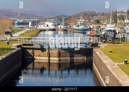 PORTE D'ÉCLUSE DU FORT WILLIAM SCOTLAND SUR LE CANAL CALEDONIAN À CORPACH AVEC DES BATEAUX AMARRÉS ET DES MAISONS Banque D'Images