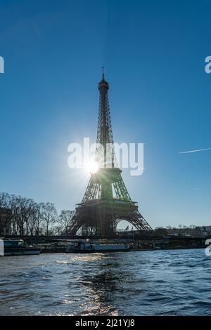 Paris, la Tour Eiffel à contre-jour, plein soleil en hiver, avec des bateaux sur la Seine Banque D'Images