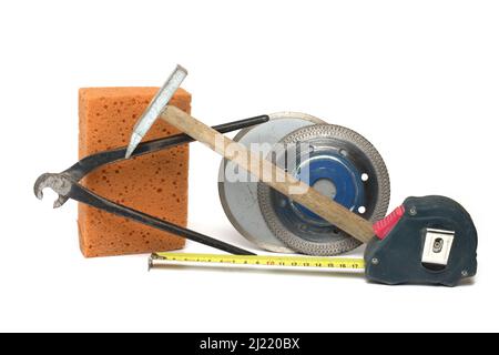Outils de gros plan pour la pose de pinces pour perroquet de carrelage, pour le marteau, le ruban de mesure et deux disques en céramique différents pour la coupe dans la meuleuse d'angle sur wh Banque D'Images
