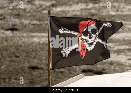 Le crâne de pirate et le drapeau de croix d'os sur le petit bateau dans le port, Royaume-Uni Banque D'Images