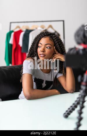 Appareil photo professionnel tournage afro-américain jeune femme blogger faisant déballage vidéo à la maison, noir biracial jeune femme vlogger influenceur Banque D'Images