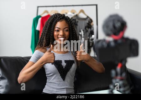 Appareil photo professionnel tournage afro-américain jeune femme blogger faisant déballage vidéo à la maison, noir biracial jeune femme vlogger influenceur Banque D'Images