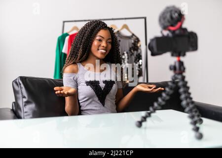 Appareil photo professionnel tournage afro-américain jeune femme blogger faisant déballage vidéo à la maison, noir biracial jeune femme vlogger influenceur Banque D'Images