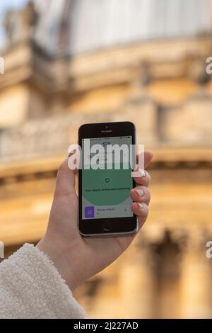 Utilisation de l'application NHS Covid sur un iPhone en dehors de la caméra Radcliffe, Oxford, Royaume-Uni Banque D'Images