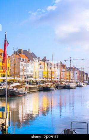 Copenhague, Danemark – 24 2022 mars : Nyhavn, lieu touristique de Copenhague, jetée avec maisons colorées et bateaux pleins de touristes qui profitent d'une journée ensoleillée Banque D'Images