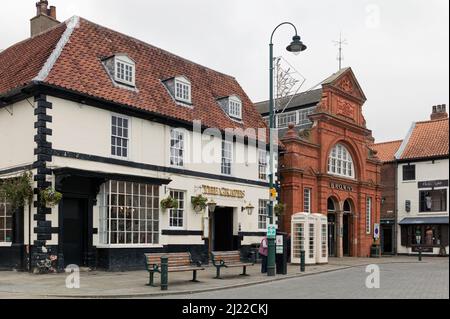 Vue de Saturday Market of English public House and Department Stores, and Traditional telephone kiosques and Bengs, Beverley, Royaume-Uni. Banque D'Images