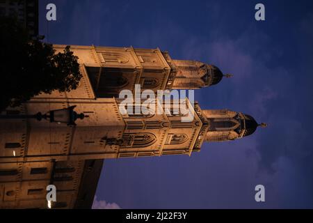 Un cliché vertical de l'église protestante de Grossmunster à Zurich, en Suisse, la nuit avec un ciel bleu foncé Banque D'Images