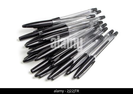 Beaucoup de stylos à bille noirs sur un fond blanc, des stylos à bille multicolores. Banque D'Images