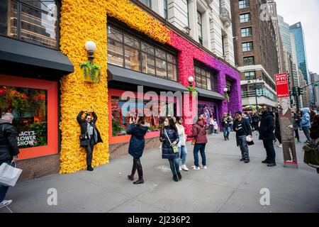 Visiteurs à l'extérieur du grand magasin phare de Macy à Herald Square à New York, qui est décoré avec des arrangements floraux pour le spectacle de fleurs de Macy, le jour d'ouverture le dimanche 27 mars 2021. Le spectacle se déroulera jusqu'au 10th avril. (© Richard B. Levine) Banque D'Images