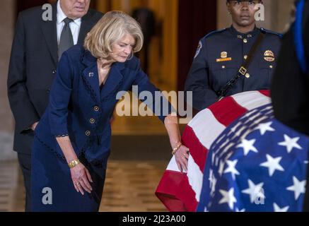 Washington, États-Unis. 29th mars 2022. Le sénateur républicain de l'Alaska Lisa Murkowski adoucit le drapeau qui couvre le rôle du représentant républicain de l'Alaska Don Young alors qu'il se trouve dans la salle de statuaire du Capitole des États-Unis à Washington DC, le mardi 29 mars 2022. Young, décédé le 18 mars 2022, était le républicain ayant le plus longtemps occupé au Congrès et représentait l'Alaska depuis 1973. Photo de piscine par Shawn Thew/UPI crédit: UPI/Alay Live News Banque D'Images