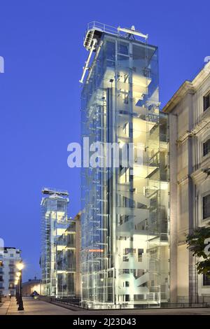 Museo Nacional Centro de Arte Reina Sofía, bâtiment du musée Reina Sofia avec ascenseurs en verre illuminés au crépuscule à Madrid en Espagne. Banque D'Images