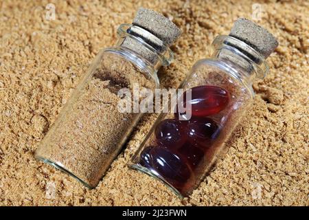 Farine de krill antarctique et capsules d'huile de krill dans des flacons en verre Banque D'Images