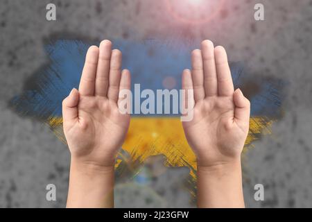 Soutien à l'Ukraine et solidarité. Les mains des enfants sur le fond du drapeau ukrainien. Le concept de confrontation et de lutte Banque D'Images