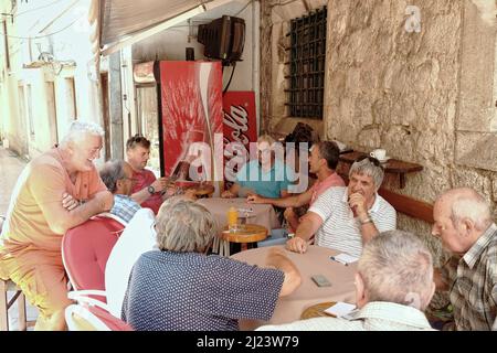 VIEILLE VILLE DE KOTOR, MONTÉNÉGRO - 19 JUILLET 2016: les gens d'âge moyen jouent aux cartes dans un bar d'une rue de Kotor dans la vieille ville Banque D'Images