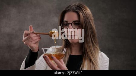 Jeune femme avec un bol de miel Banque D'Images