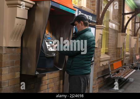 Un homme effectuant un appel sur un téléphone payant Banque D'Images