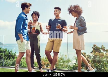 Ils étaient si heureux d'être enfin ici ensemble. Prise de vue d'un groupe d'amis prenant un verre et s'appréciant dehors pendant les vacances. Banque D'Images