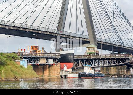 30 mars 2022, Glebe Island Bridge, Sydney, Australie : le navire à vapeur côtier de 1927, John Oxley ayant subi des années de restauration et de préservation, est photographié ici sur le chemin d'être finalement renfloué après 21 ans montés sur un ponton aux ateliers de la Sydney Heritage Fleet à Roselle Bay. Après avoir facilement dégagé l'immense pont ANZAC en béton, le ponton passe par l'ouverture de l'ancien pont Glebe Island sur son chemin vers un quai sec à Garden Island, plus loin en bas du port de Sydney où il sera soigneusement rénové et testé. Banque D'Images