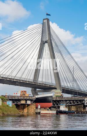 30 mars 2022, Glebe Island Bridge, Sydney, Australie : le navire à vapeur côtier de 1927, John Oxley ayant subi des années de restauration et de préservation, est photographié ici sur le chemin d'être finalement renfloué après 21 ans montés sur un ponton aux ateliers de la Sydney Heritage Fleet à Roselle Bay. Après avoir facilement dégagé l'immense pont ANZAC en béton, le ponton passe par l'ouverture de l'ancien pont Glebe Island sur son chemin vers un quai sec à Garden Island, plus loin en bas du port de Sydney où il sera soigneusement rénové et testé. Banque D'Images