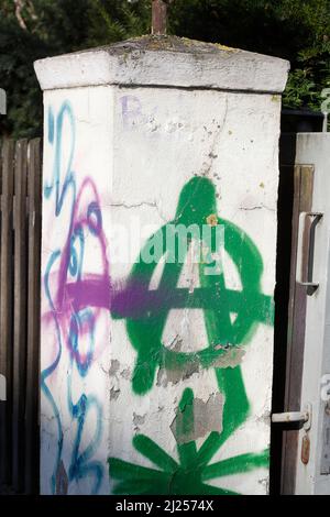 Vert A pour l'anarchie peint sur le mur de jardin blanc Banque D'Images