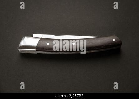 Couteau de poche traditionnel en bois sur fond noir Banque D'Images