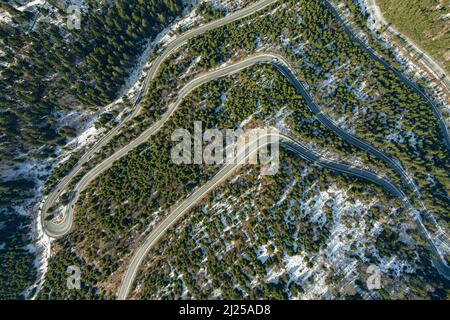Photo aérienne de certains serpentins de route. Serpentine enneigée dans les montagnes avec des arbres Banque D'Images