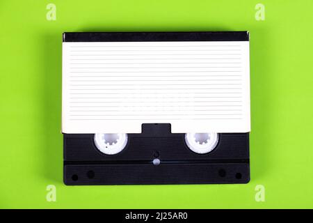 Cassette vidéo rétro avec une boîte sur fond de papier vert Banque D'Images