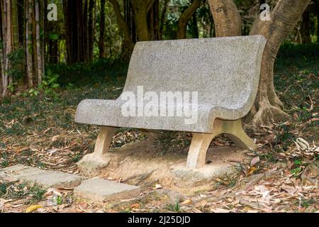 Gros plan d'un banc de pierre dans un parc forestier Banque D'Images