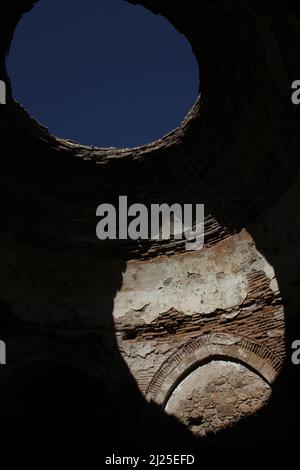 Ciel bleu du toit d'une ancienne église. Lumière tombant sur le mur du trou sur le plafond. À l'intérieur des ruines du vieux millésime historique Banque D'Images