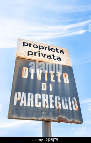Vieux panneau rouillé pour une place de stationnement privée indiquant que l'étiquette est interdite (traduit de la langue italienne). Banque D'Images