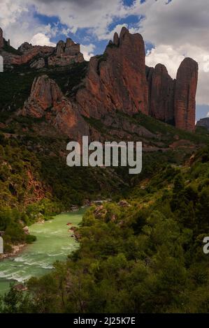 Rafting en eau vive, escalade, randonnée et observation des oiseaux : toutes les activités de loisirs populaires au milieu des imposantes falaises rouges des Mallos de Riglos et sur les eaux en surge de la rivière Gallego en contrebas. Los Mallos (les maillets), dans la province de Huesca, Aragon, Espagne, ont au moins 20 millions d'années. Elles s'élèvent à environ 300 m (980 pi) et forment une passerelle naturelle spectaculaire vers les Pyrénées. Banque D'Images