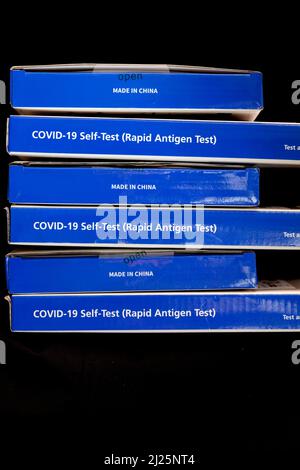 Boîtiers de kit de test de débit latéral Blue NHS Covid-19 / kits de test de coronavrus à antigène de débit latéral rapide sur fond noir Banque D'Images