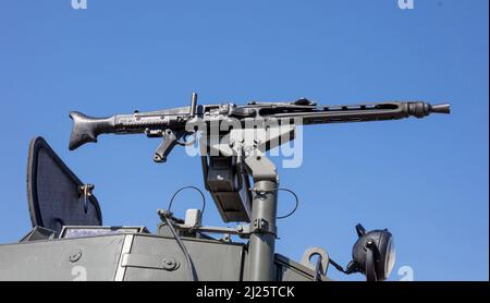 Mitrailleuse sur une tourelle de transport de personnel blindé, défilé militaire. Arme lourde de guerre, fond bleu ciel. Équipement de l'armée pour la lutte et la défense Banque D'Images