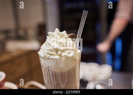Délicieux milkshake glaçant au chocolat avec beignets et bonbons. Tendance à la fréakshake. Copier l'espace Banque D'Images