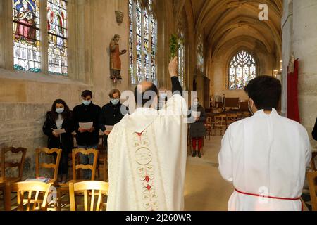 Messe du dimanche à l'église Saint Nicolas, Beaumont-le-Roger, Eure, France. Bénédiction prêtre paroissiens avec paume Banque D'Images