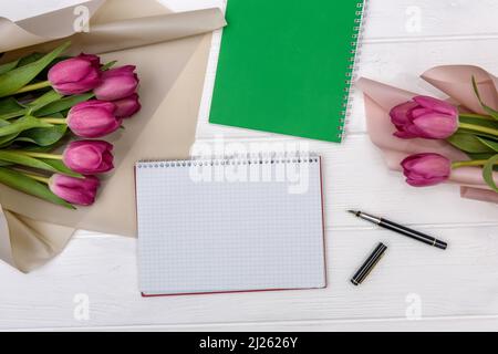 Ouvrez le bloc-notes vierge et le bouquet de fleurs de tulipe roses Banque D'Images