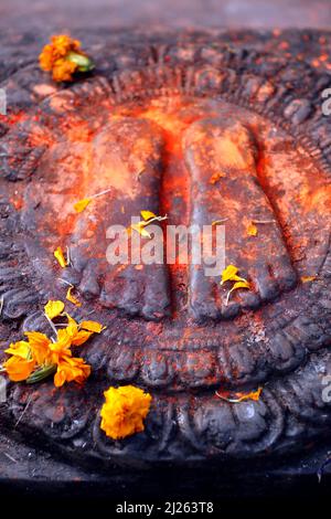 Mandala. Bouddha peint en rouge deux pieds et fleurs offrandes. Banque D'Images