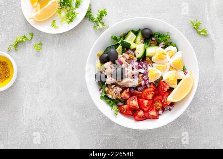 Salade de thon et de légumes frais de tomates, concombres, olives, oignons, laitue et œufs durs, vue du dessus Banque D'Images