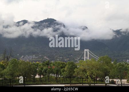Un beau paysage des montagnes couvertes de nuages avec la vue sur la ville au fond Banque D'Images