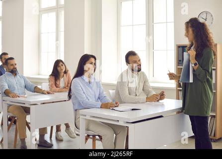 L'enseignant ou le coach d'affaires communique avec un groupe d'élèves adultes pendant une conférence. Banque D'Images