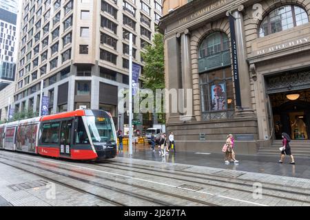 Train léger en train de Sydney le long de George Street dans le centre-ville de Sydney, en Nouvelle-Galles du Sud, en Australie, lors d'une journée de marche humide en automne Banque D'Images