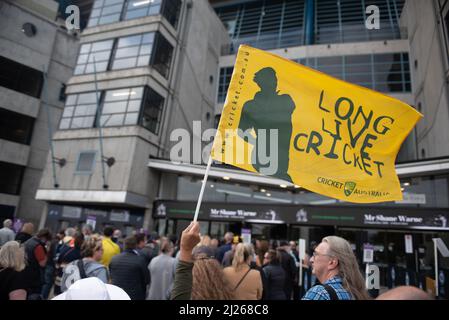 Melbourne, Australie. 30th mars 2022. Un fan assistant au Mémorial de Shane Warne au MCG fonde un drapeau indiquant « long Live Cricket ». Credit: Jay Kogler/Alay Live News Banque D'Images