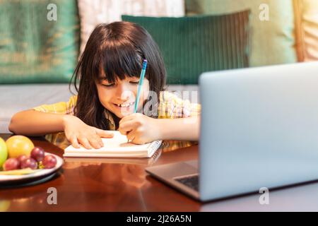 jeune étudiant utilisant un ordinateur portable pour étudier en ligne à partir de la maison regardant la leçon de web ou à l'écoute d'un tuteur par appel vidéo. l'apprentissage à distance Banque D'Images