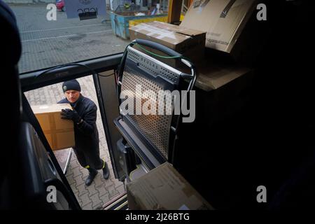 Une garde charge les fournitures d'aide dans un bus appartenant au volontaire britannique Cliff Wilson qui les transportera de Przemysl en Pologne à l'Ukraine et, à son retour, ramasse les femmes et les enfants ukrainiens et les ramasse à la frontière en Pologne. Date de la photo: Mercredi 30 mars 2022. Banque D'Images